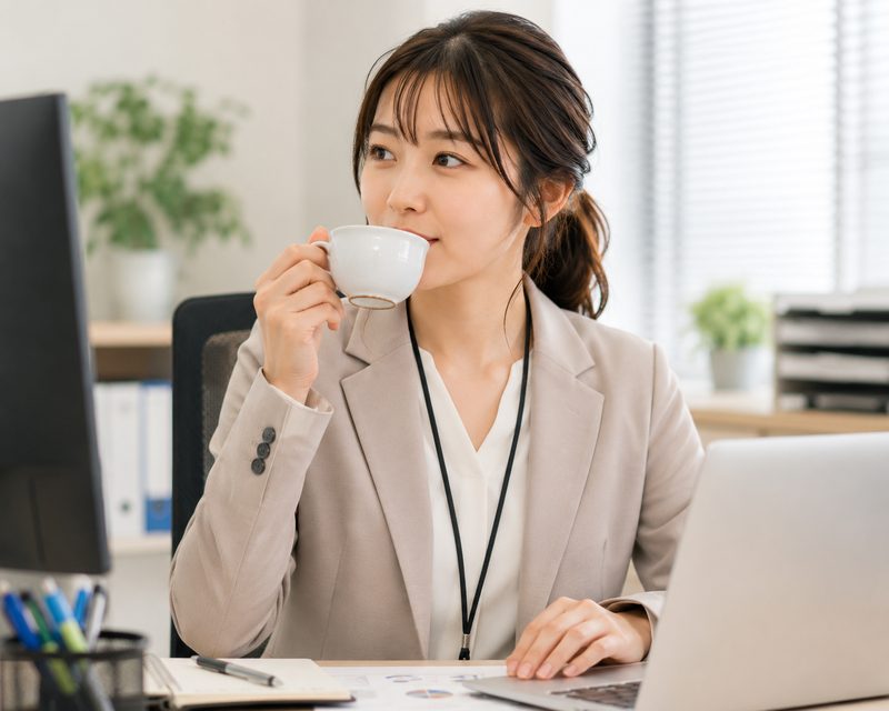 仕事中にお茶を飲む会社員女性